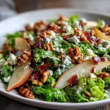 Frisée Pear Blue Cheese Bowl with crispy prosciutto, ripe pears, and crumbled blue cheese, ready to serve.
