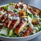 Shredded parmesan and crunchy croutons top this fresh Caesar Chicken Bowl.