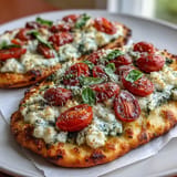 Delicious viral cottage cheese flatbread, generously topped with vibrant pesto, tomatoes, basil.