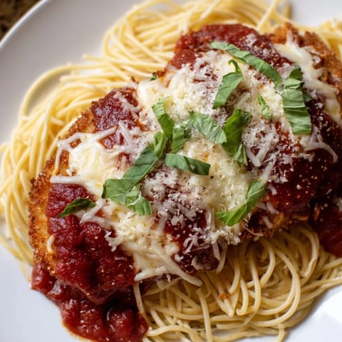 A close-up of a plated Chicken Parmesan, visually delicious with melted mozzarella over crispy chicken.