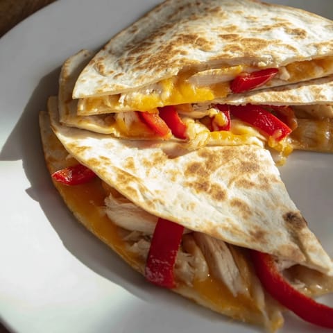 Golden, cheesy Chicken Quesadilla with grilled chicken and peppers, ready to be sliced and served.
