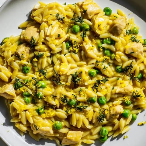 A close-up view of a hearty Lemon Herb Chicken Orzo Skillet garnished with chopped parsley and dill, ready to serve.