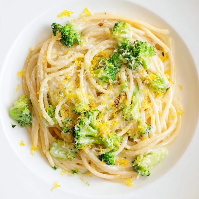 Plated One-Pot Lemon Broccoli Pasta beside a glass of crisp white wine, highlighting tender broccoli and lemon zest in a single-pot family dinner.