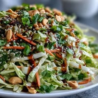 Freshly shredded green and red cabbage tossed in ginger sesame dressing for Asian Cabbage Salad.
